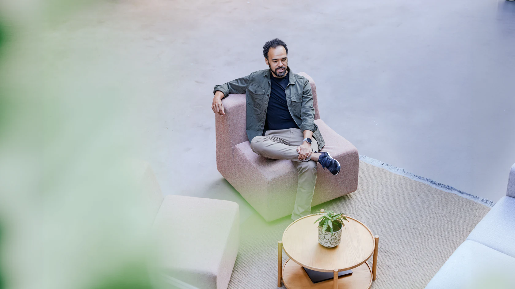 Kyle Welsworth lounging on a dusty-pink sofa, seen from above